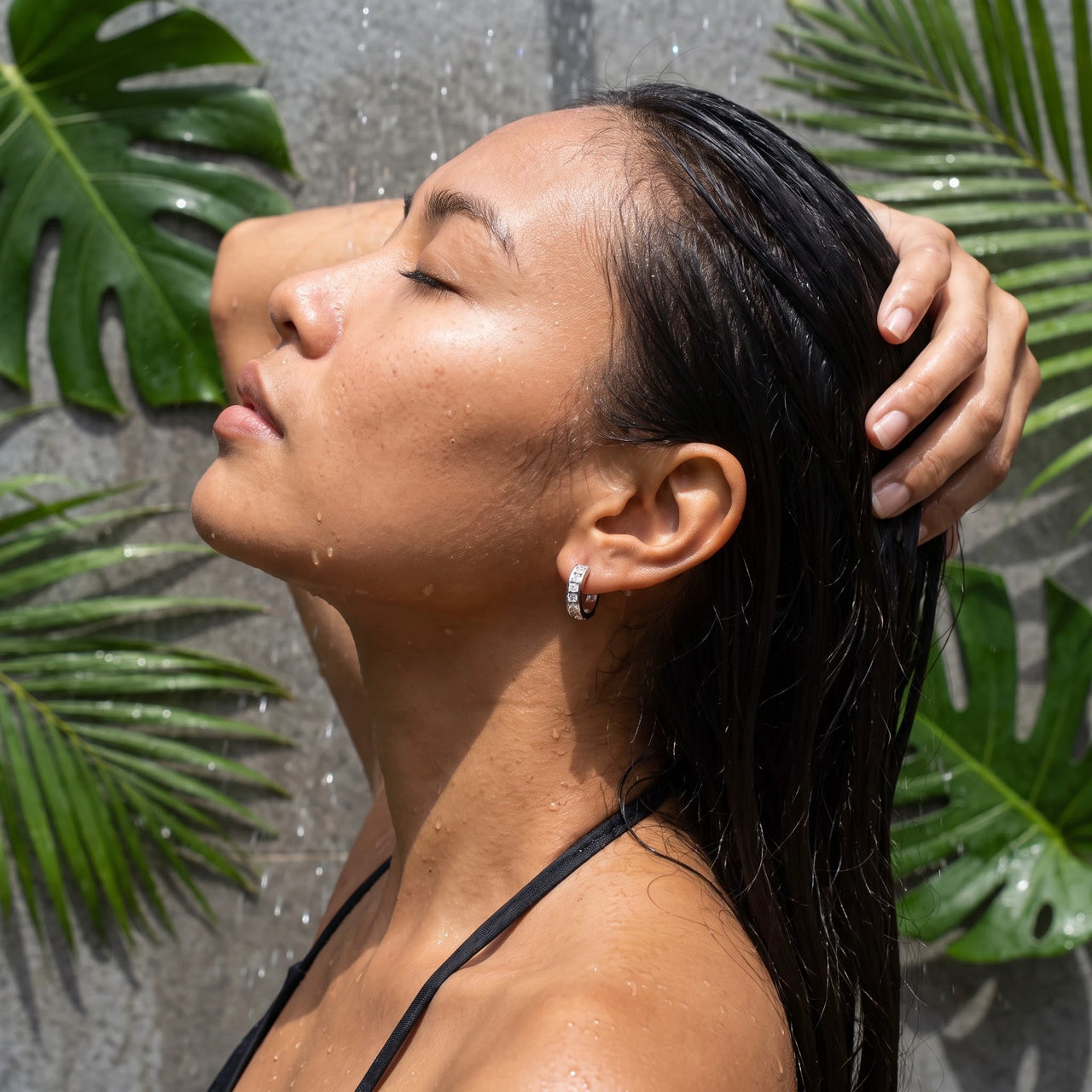 Silver huggie hoop earrings worn in a tropical outdoor shower | SKU: 22023999-rhodium