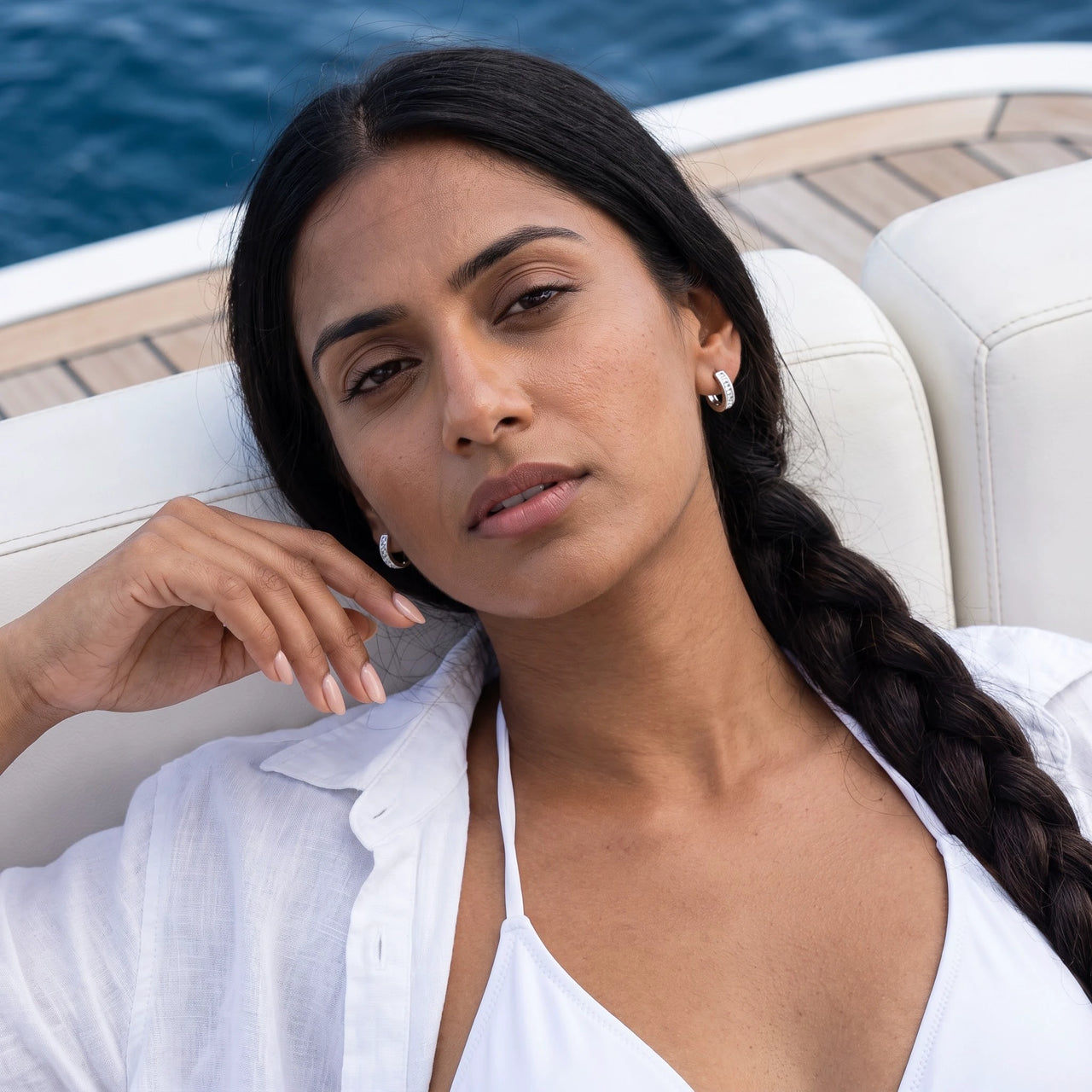 Woman on a yacht wearing the silver huggie hoop earrings | SKU: 22023999-rhodium