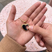Thumbnail for Thumb warming the gold heart pendant: the hidden photo appears under the thumb while the rest stays black | SKU: TPH-CHTN-GOLD-SMALL